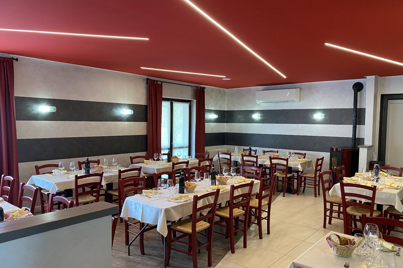 La sala con soffitto rosso, tovaglie bianche e sedie rosse